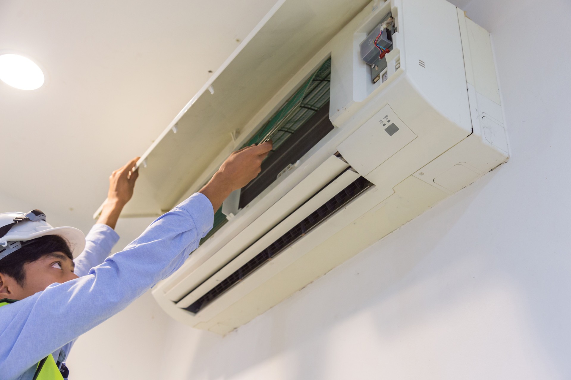 Low Angle View Of Technician Cleaning Air Conditioner On Wall