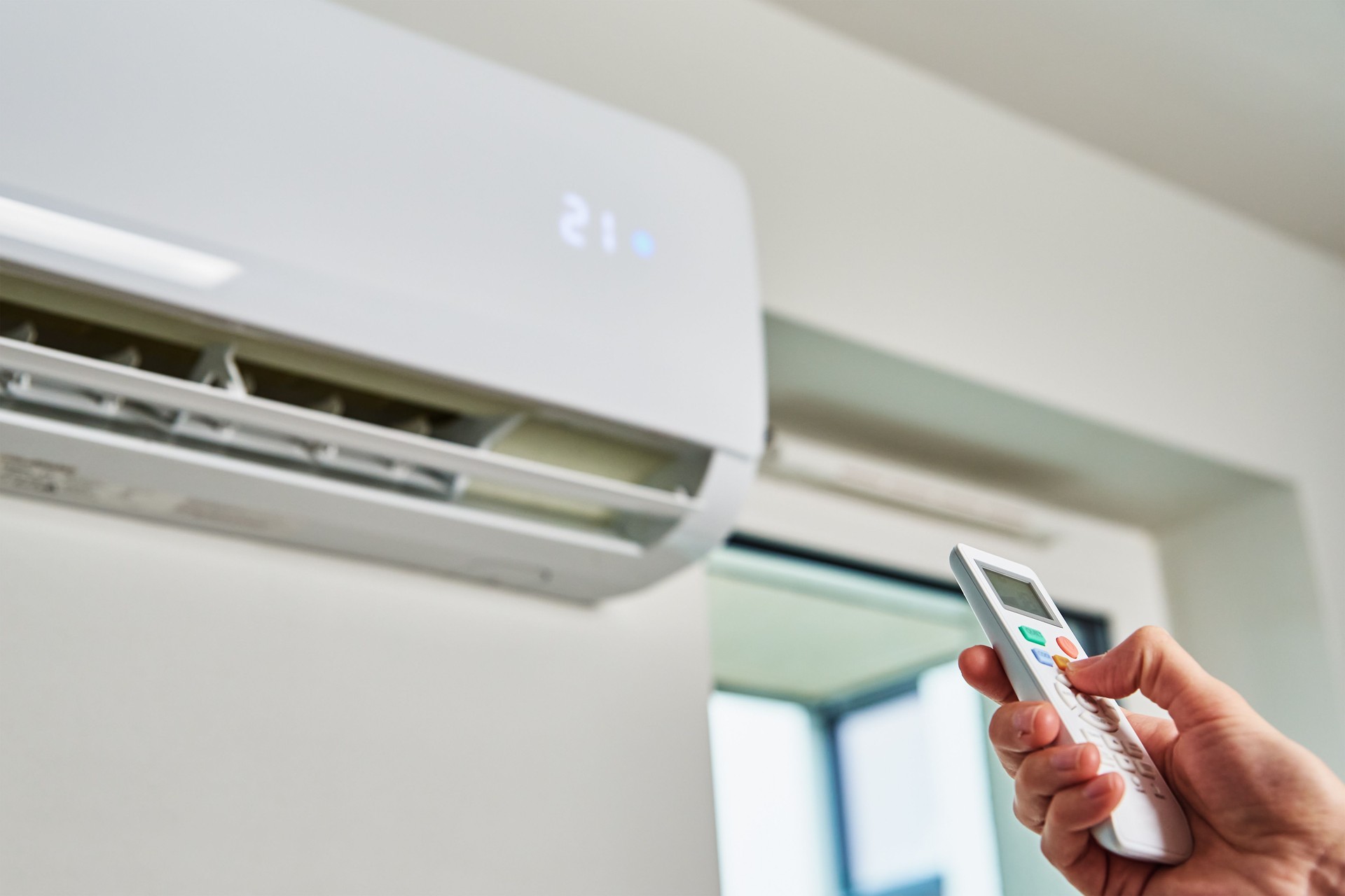 Hand adjusting temperature on air conditioner